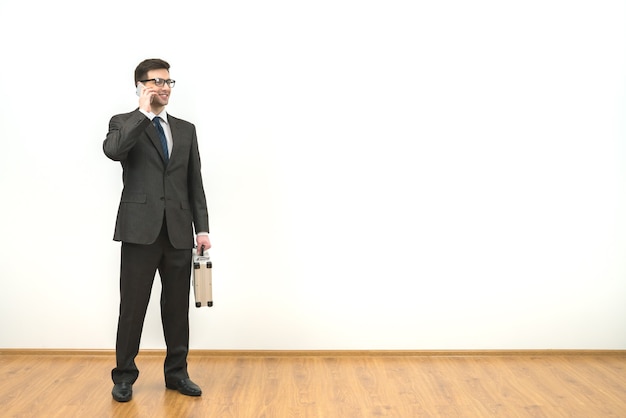 Zdjęcie mężczyzna z telefonem etui na tle białej ściany