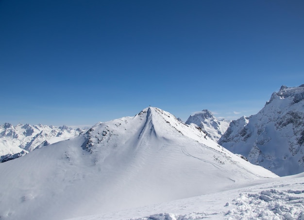 Mężczyzna ze snowboardem na szczycie zaśnieżonej kaukaskiej góry