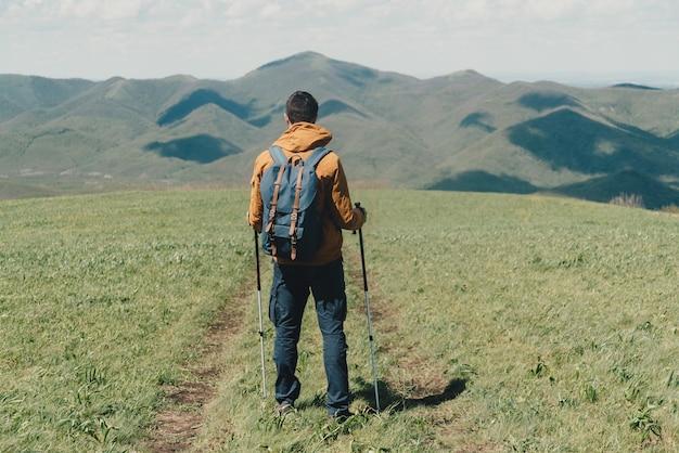 Mężczyznę idącego z kijkami trekkingowymi