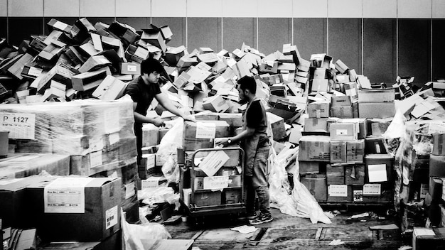Zdjęcie mężczyźni pracujący z kartonowymi pudełkami w magazynie