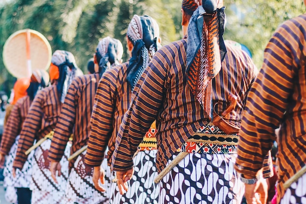 Mężczyźni w tradycyjnych strojach jawajskich z keris batik i blangkon, aby pokazać bogactwo kultury jawajskiej na karnawale w Yogyakarcie