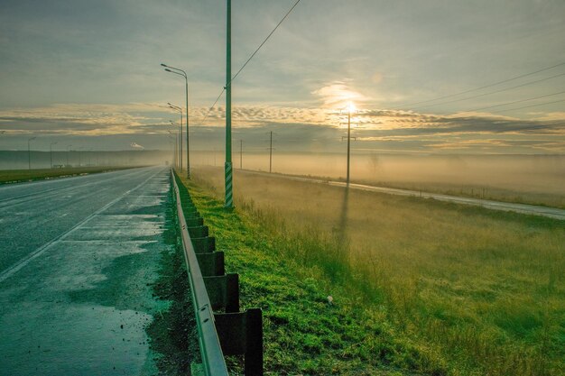 Mgła na drodze wzdłuż pola o świcie mgła na jesiennym polu wzdłuż autostrady Uljanowsk