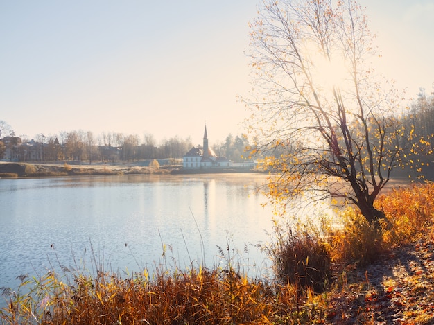 Mgłowy słoneczny jesień krajobraz ze starym pałacem. Gatchina. Rosja.