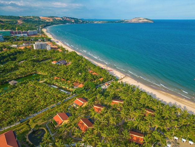 Miasto Mui Ne Binh Thua widok z lotu ptaka z pięknym zachodem słońca i tyloma łodziami Panoramiczny widok na wybrzeże Mui Ne z góry z falami Wybrzeża ulice drzewa kokosowe Phan Thiet