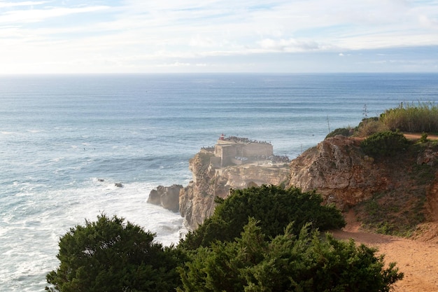 Miasto Nazare w Portugalii symbol surfingu Linia brzegowa i widok z góry na miasto Miejsce turystyczne z dużymi falami Zdjęcie krajobrazu