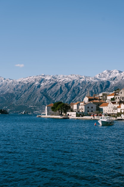 Miasto Perast na tle pokrytych śniegiem gór