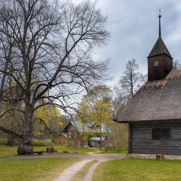 Miasto Tallinn w Estonii. Muzeum Etnograficzne w plenerze. Tradycyjny drewniany kościół z bali, kryty strzechą we wsi