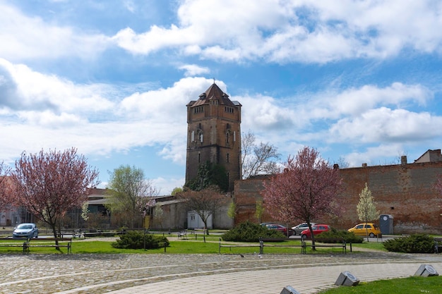 Miasto to miasteczko z wieżą i kościołem w tle.