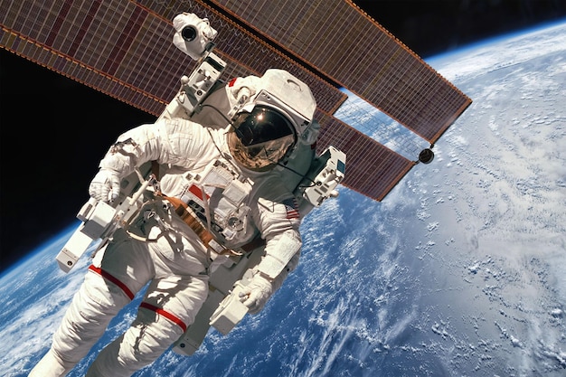 Międzynarodowa Stacja Kosmiczna i astronauta w przestrzeni kosmicznej nad planetą Ziemia. Elementy tego obrazu dostarczone przez NASA.