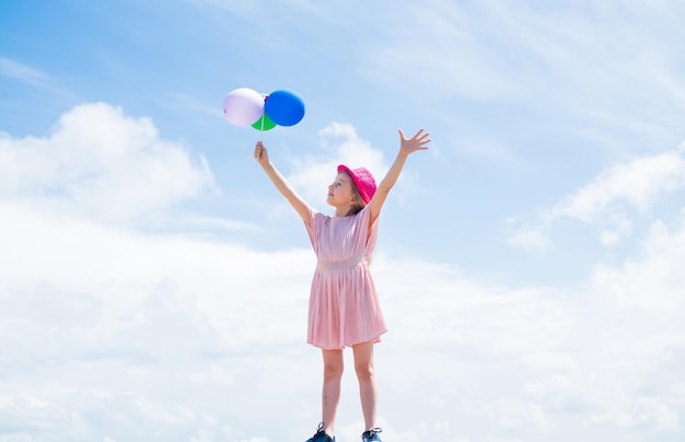 Międzynarodowy dzień dziecka szczęśliwe dzieciństwo małe dziecko z balonami Rozrywka koncepcja urodzinowa wolność dziecko bawiące się i tańczące z balonami w rękach dziecko bawiące się