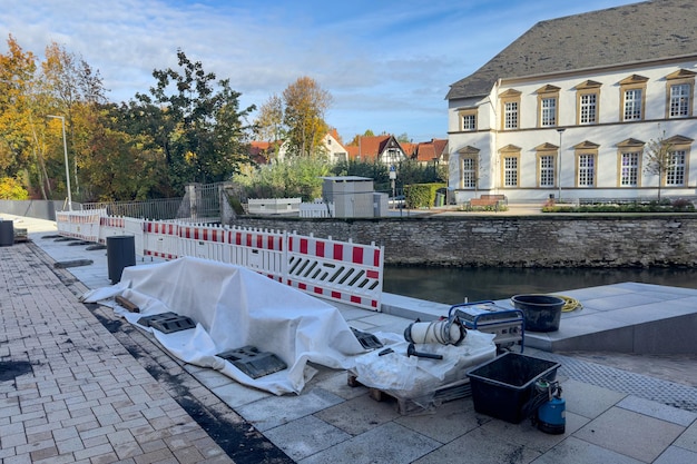 Miejsce budowy z świeżo utwardzoną ścieżką ogrodzoną plastikowymi barierami i drzewami w budynku