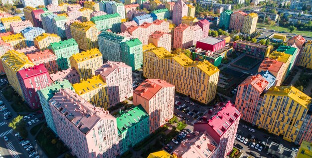 Miejski krajobraz kolorowych budynków. Widok z lotu ptaka na kolorowe budynki w europejskim mieście w porannym słońcu. Pejzaż z wielokolorowymi domami, samochodami na ulicy w Kijowie, Ukraina