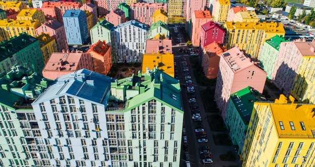 Miejski krajobraz kolorowych budynków. Widok z lotu ptaka na kolorowe budynki w europejskim mieście w porannym słońcu. Pejzaż z wielokolorowymi domami, samochodami na ulicy w Kijowie, Ukraina