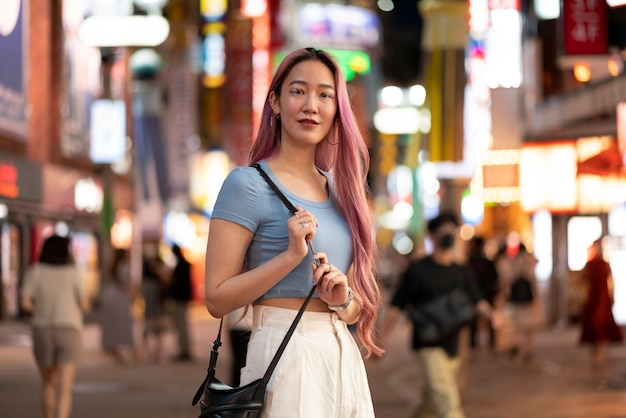 Zdjęcie miejski portret młodej kobiety z długimi różowymi włosami