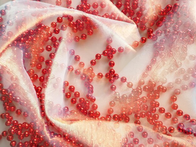 Miękka biała przezroczysta tkanina i czerwone koraliki Piękne kobiece rzeczy Tło dla motywu piękna