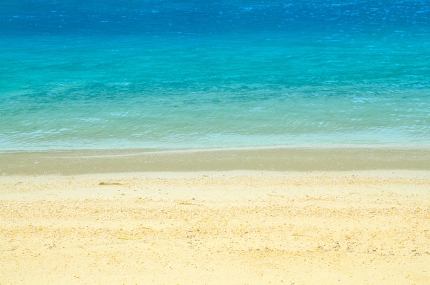 Miękka fala błękitny ocean na piaskowatej plaży. Tło.