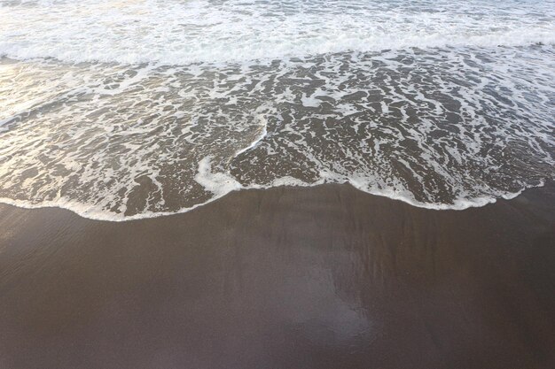 Miękka fala błękitny ocean na piaskowatej plaży. Tło.