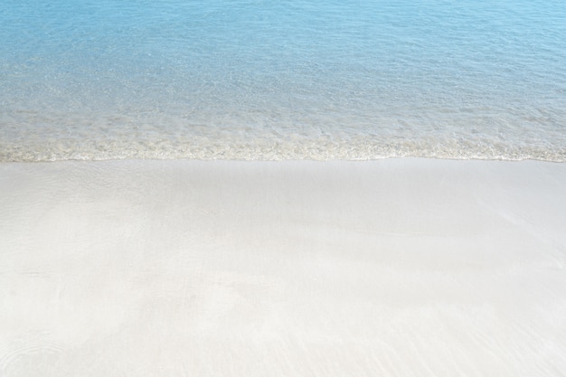 Miękka fala niebieski ocean na piaszczystej plaży. Tło lato.