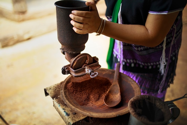 Mielenie nasion kawy według starej tradycji w Tajlandii