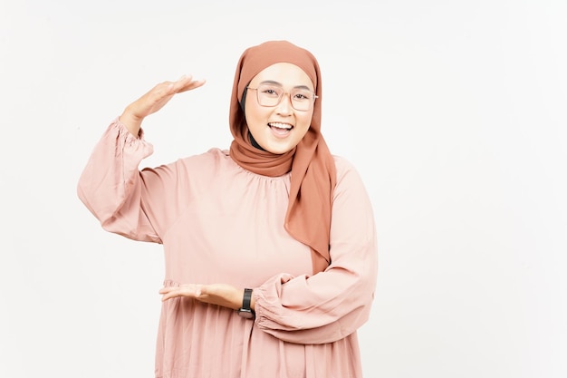 Mierząc i pokazując duży znak produktu pięknej azjatyckiej kobiety noszącej hidżab na białym tle