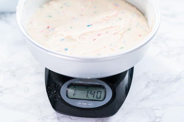 Mierzenie ciasta na wagę na cyfrowej wadze kuchennej.