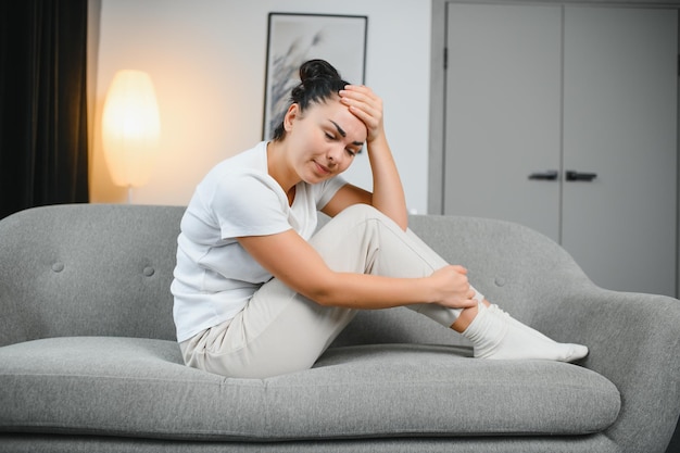 Miesiączka cykl dzień miesiąc młoda kobieta kobieta ręka w bólu brzucha cierpi na PMS przedmiesiączkowy ból brzucha lub brzucha na łóżku w domu Problem zdrowotny Zapalenie organizmu