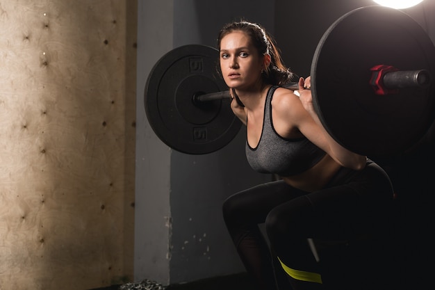 Mięśniowa Kobieta W Gym Robi Ciężarowi ćwiczy Z Sztangą