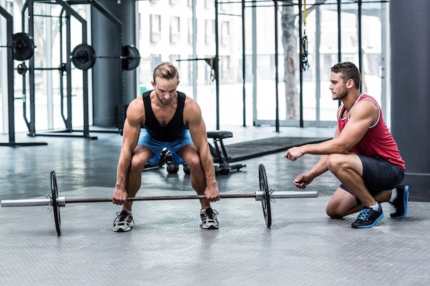 Mięśniowy mężczyzna podnosi barbell