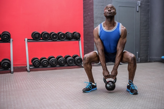 Mięśniowy mężczyzna podnosi kettlebell