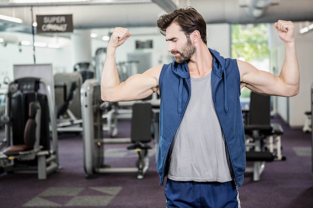 Mięśniowy Mężczyzna Pokazuje Bicepsy Przy Gym