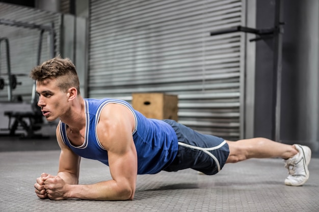 Mięśniowy mężczyzna zaszaluje przy gym crossfit