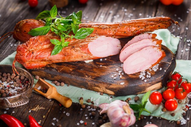 Zdjęcie mięsny przysmak, piękna gotowana wieprzowina, cała lub pokrojona na kuchennej desce do krojenia, ciemna i nastrojowa