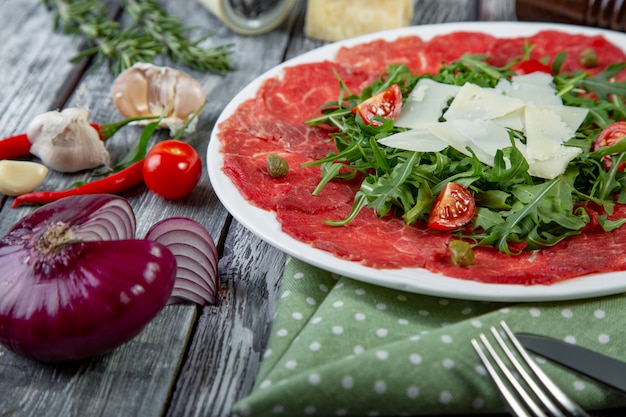 Mięso carpaccio z bliska z rukolą i plasterkami parmezanu