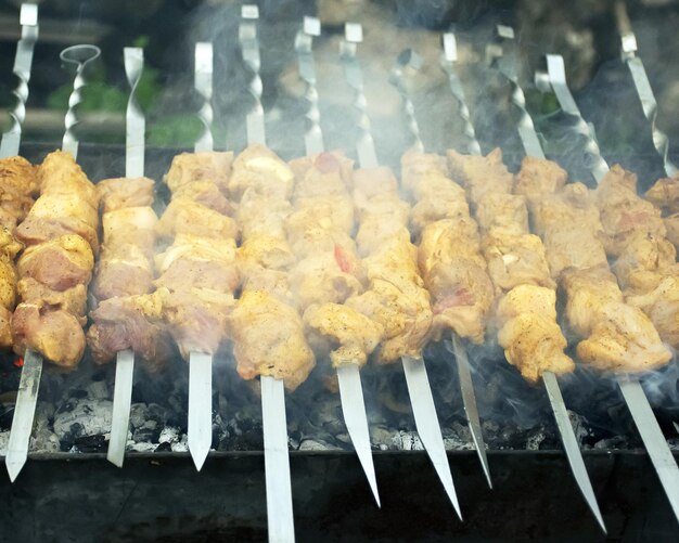 Mięso gotuje się na rozżarzonych węglach w dymie Piknik w naturze Wieprzowina smażona na grillu