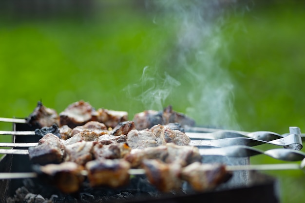 Zdjęcie mięso grillowe na szaszłykach. gotowanie szaszłyka na mangalu w naturze. szaszłyk z grilla gotowanie na metalowym szpikulcu. domowy piknik