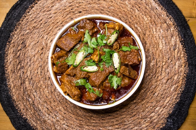 Zdjęcie mięso wołowe mezbani gosht korma karahi podawane w naczyniu izolowanym na drewnianym tle widok z góry indyjskie przyprawy bangladeskie i pakistańskie jedzenie