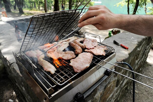 Mięso z grilla na grillu Kolacja koncepcja przyjęcia na piknik Grillowane jedzenie w tle Las w tle Skopiuj miejsce