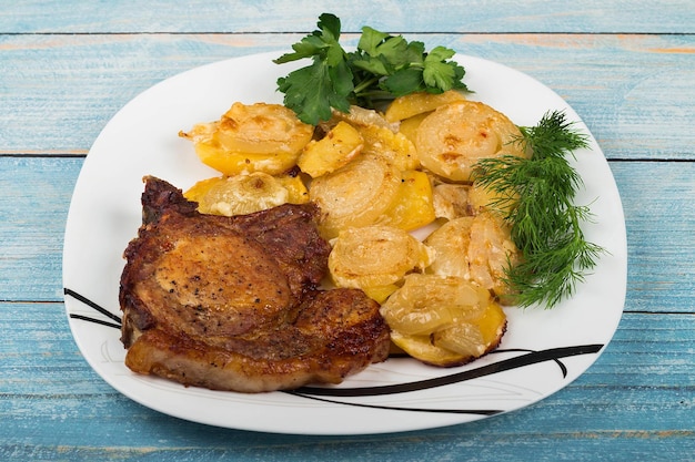 Zdjęcie mięso z grilla z warzywami i ziołami na talerzu drewnianym tle