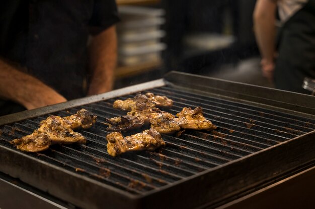 Zdjęcie mięso z kurczaka jest grillowane w otwartej kuchni restauracji