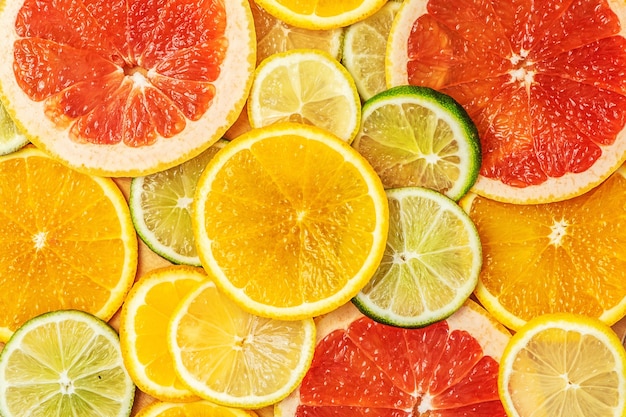 Mieszane świeże Plasterki Owoców Cytrusowych Jako Tło. Różne Rodzaje Pomarańczy Cytrusowych, Limonki, Mandarynki, Grejpfruta, Cytryny. Widok Z Góry.