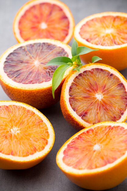 Mieszanka owoców cytrusowych pomarańczy, figi, limonki na szarym tle.