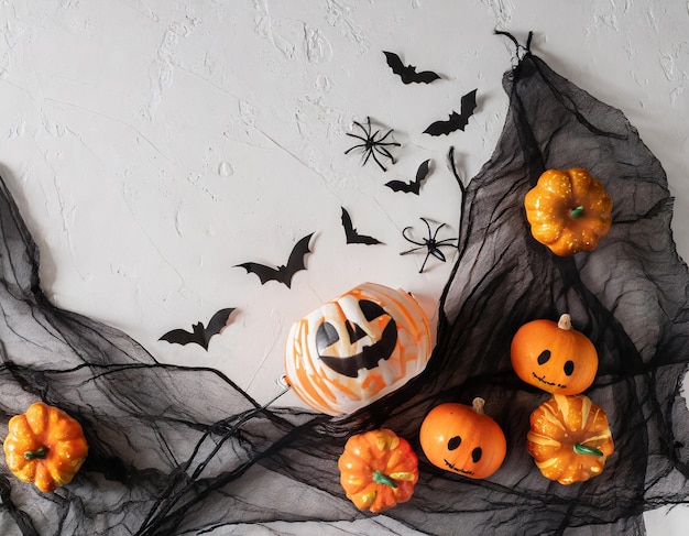 Zdjęcie mieszkanie na halloween z maską dyni, kapeluszem wiedźmy, latającymi nietoperzami, ozdobną siecią i strasznym duchem
