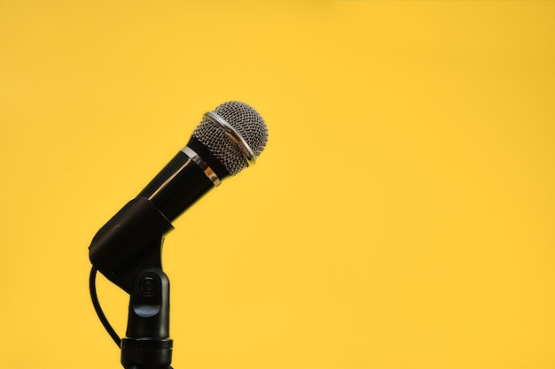 Zdjęcie mikrofon na białym tle na żółtym tle, koncepcja komunikacji.