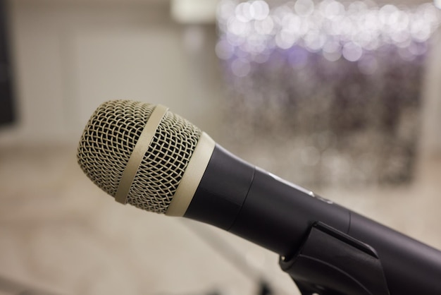 Mikrofon nad abstrakcyjnym niewyraźnym zdjęciem sali konferencyjnej lub sali seminarowej