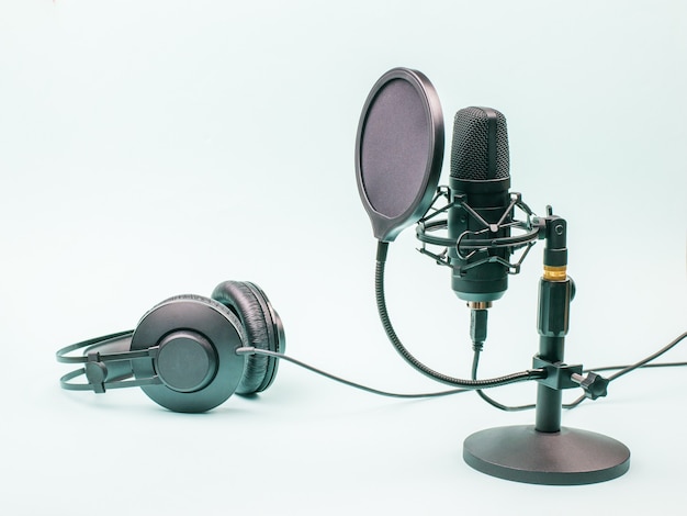 Mikrofon Pojemnościowy I Przewodowe Słuchawki Na Niebieskim Tle. Sprzęt Do Nagrywania I Odtwarzania Dźwięku.