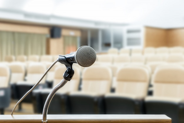 Mikrofon stoj? Na podium z abstrakcyjne rozmycie zdj? Cie sali konferencyjnej lub seminarium pokoju w tle