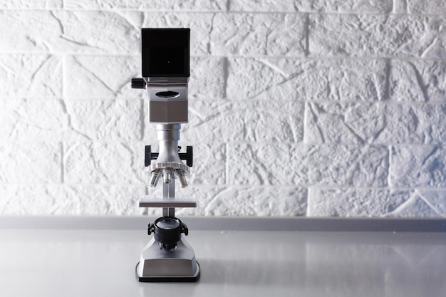 mikroskop stoi na stole na białym tle