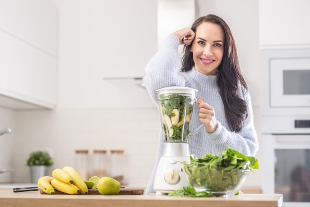 Mikser napakowany witaminami, gotowy do zmiksowania w smoothie przez piękną kobietę.