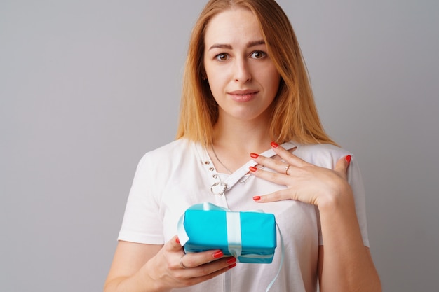 Miła kobieta trzyma niebieskie pudełko w jej ręce