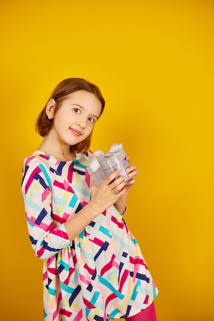 Miła nastolatka trzyma srebrne pudełko w dłoni w studio